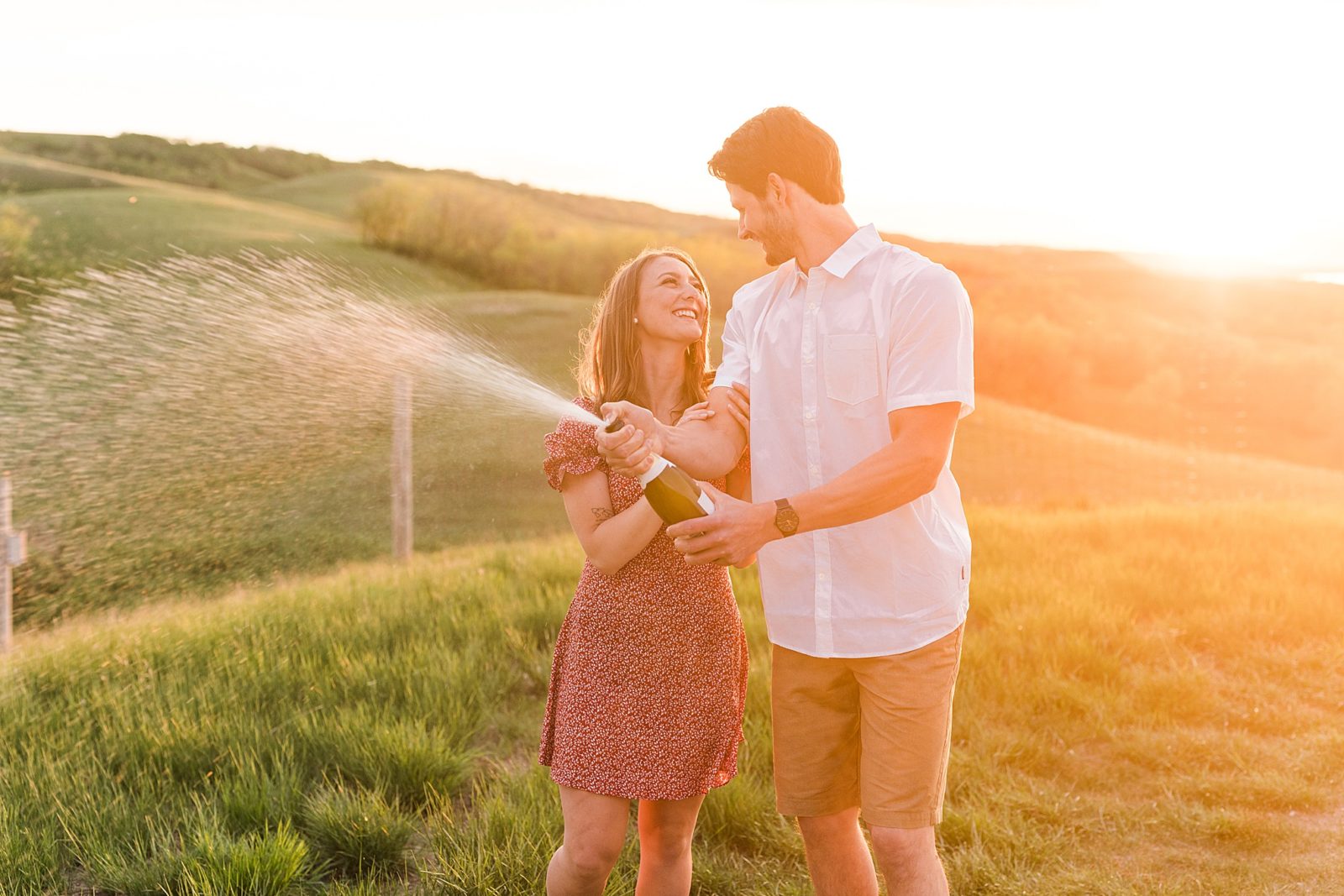Buffalo Pound, engagement session couple on a hill at golden hour with a champagne spray