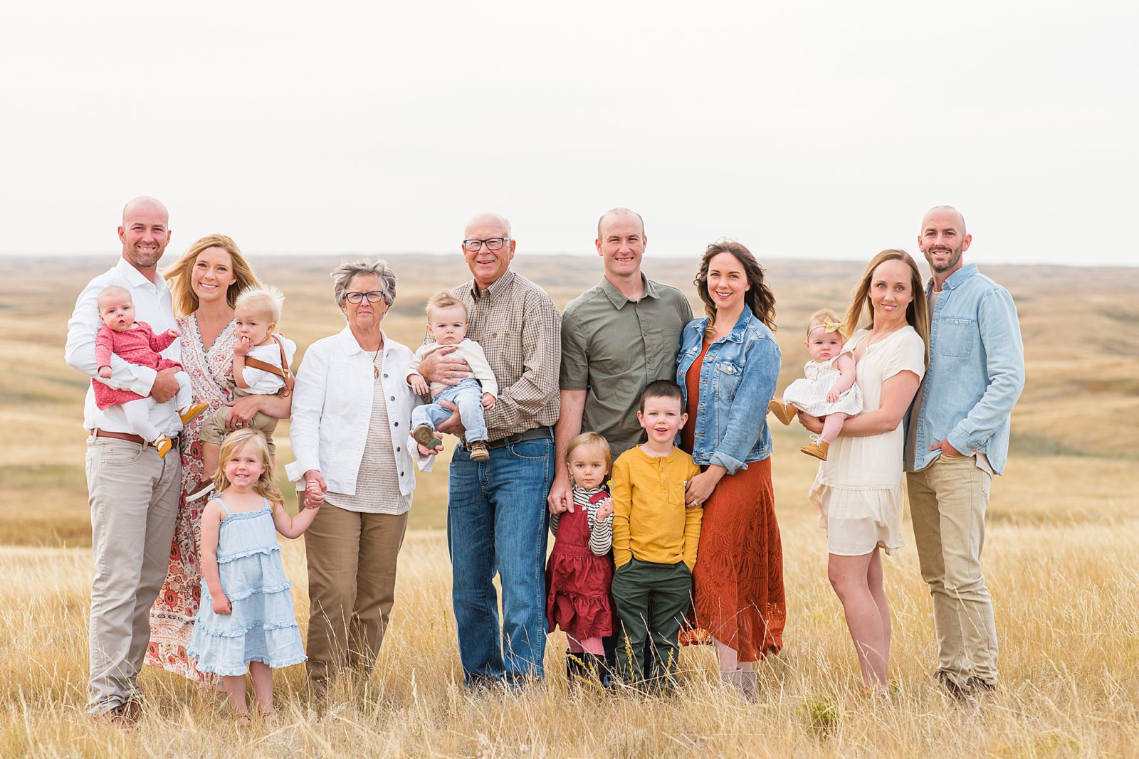 extended family standing on a hill in the middle of the prairies with many kids
