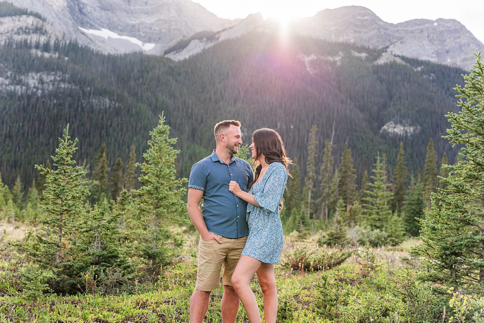 Couple standing in front of mountains in Kananaskis looking at eachother