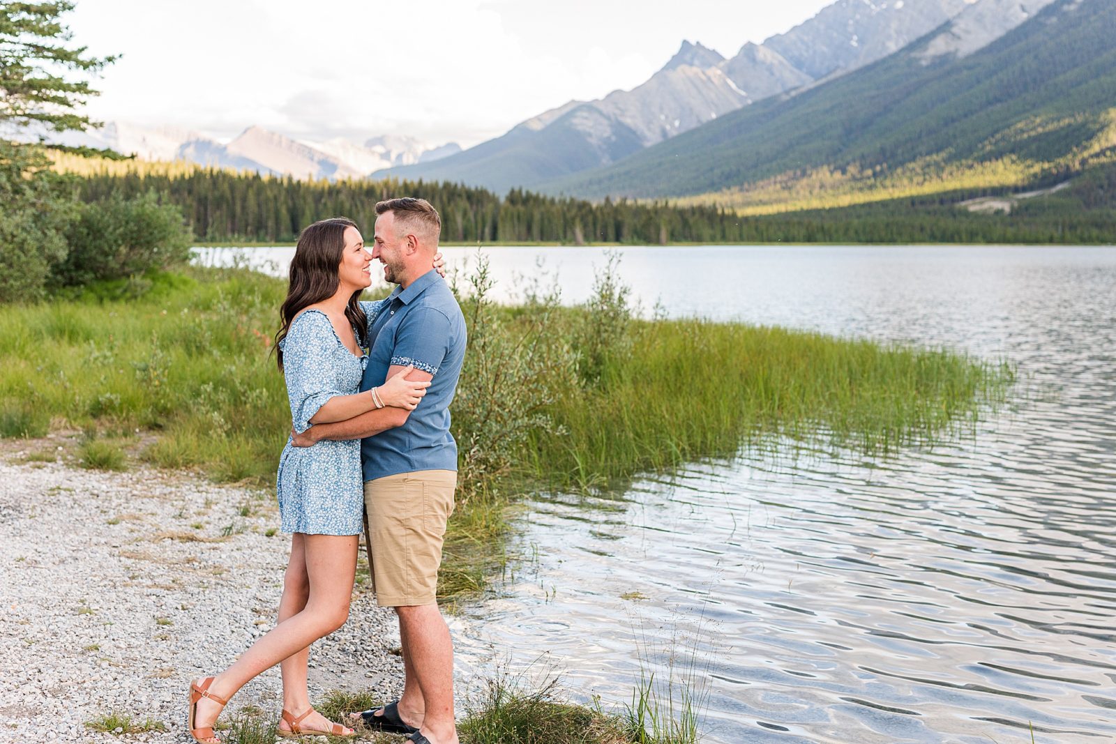 Couple standing in front of mountains  in a lake in Kananaskis 